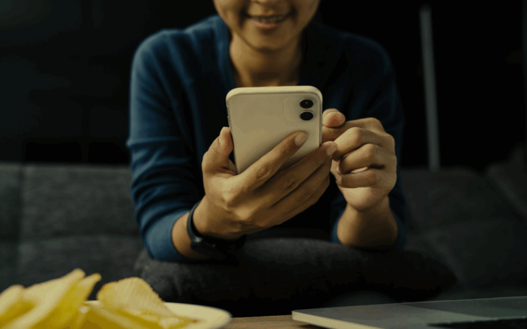 A person is captured interacting with a smartphone, implying the importance of mobile devices in modern daily activities.