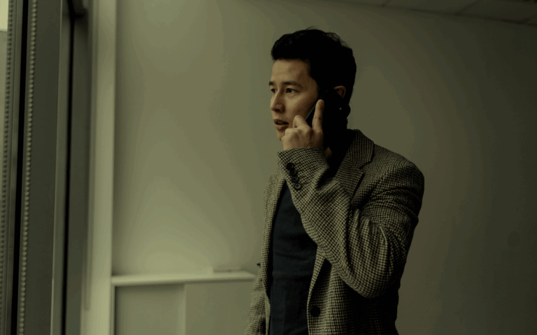 A man in a checkered jacket speaking on a mobile phone, suggesting the need for professional communication.